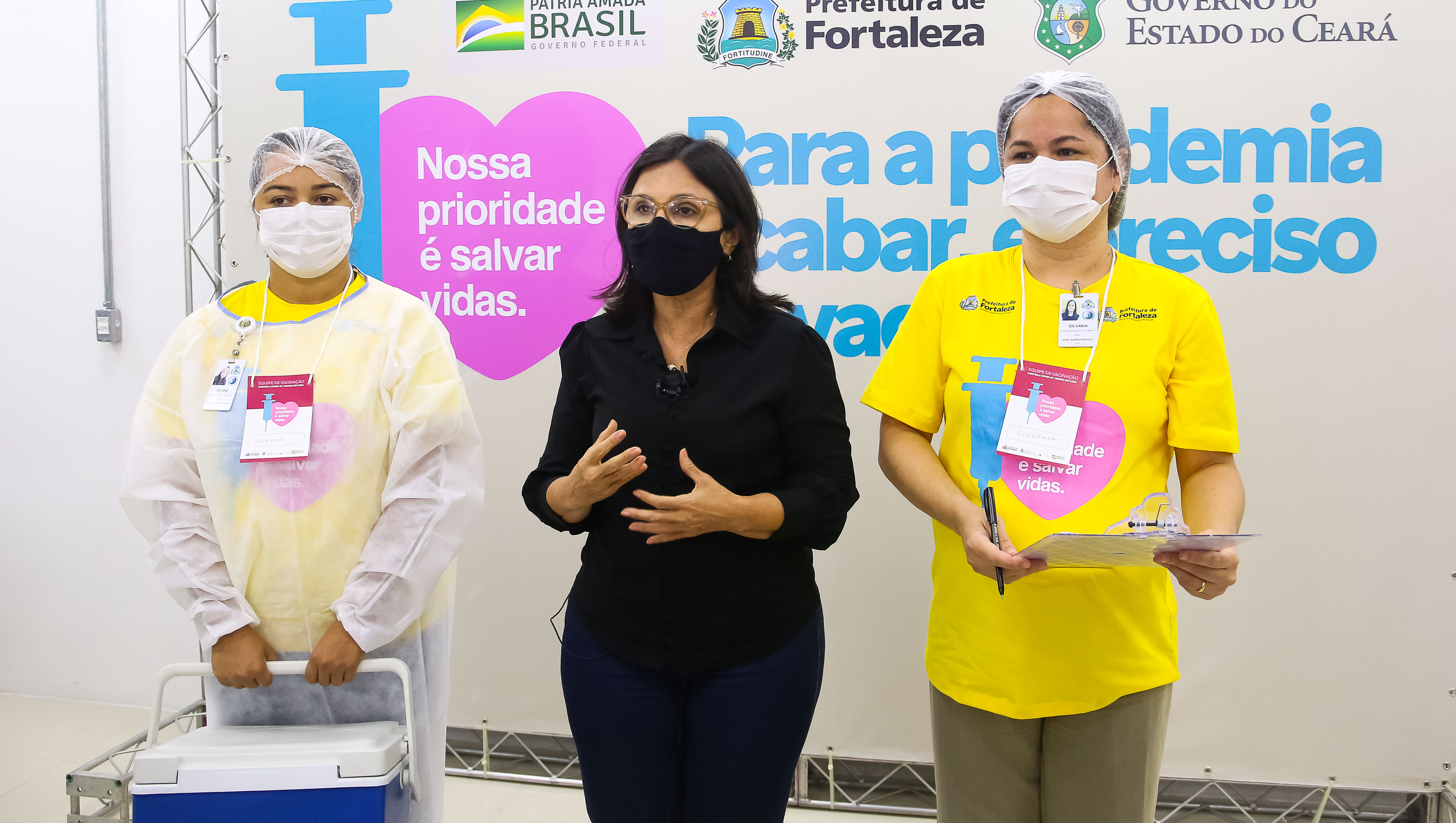 secretária ana estela e duas enfermeiras com o uniforme que identifica as equipes de vacinação domiciliar: camisa amarela e equipamentos de EPI